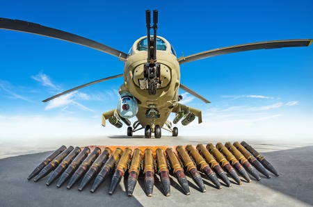 Military helicopter is parked, in the foreground the cartridges are the weapons that it shootsの写真素材