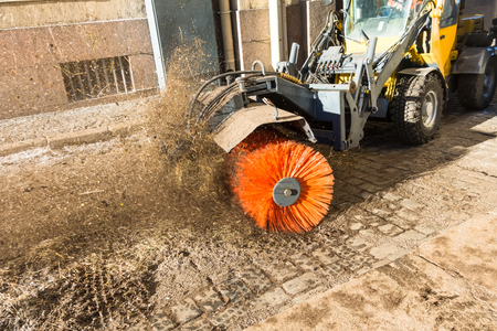 Street cleaning, rotating brush on the cleaning equipment, sweeps up garbage in the cityの写真素材
