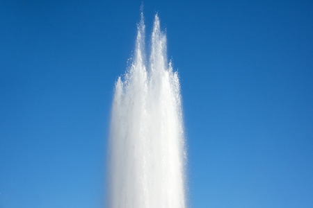 Powerful discharge of water fountain, geyser against the blue skyの写真素材