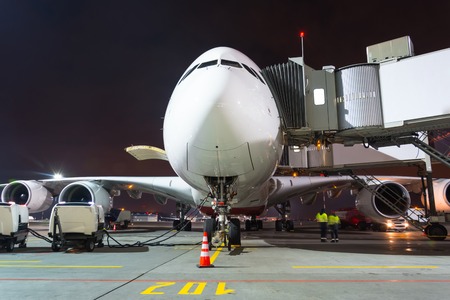 Nose and cockpit airplane gangway of the terminal building at the airport at night, aircraft flight maintenanceの写真素材