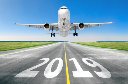 The inscription on the runway 2019 surface of the airport runway texture with take off airplane. Concept of travel in the new year, holidaysの写真素材