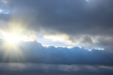 Rays of light shining through dark clouds, dramatic sky with cloudの写真素材