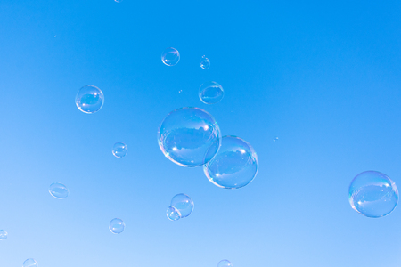 Soap bubble fly on blue sky backgroundの写真素材