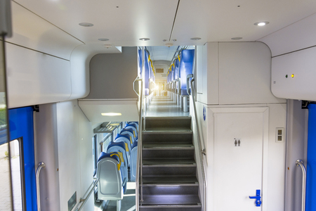 Salon inside of the speed commuter train with empty seats staircase to the second floorの写真素材