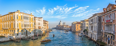 Grand Canal in Venice, Italy. Wide view of the main street panorama of the major street of Venice with motor boats with beautiful picturesque clouds in the sky. Basilica di Santa Maria della Saluteの写真素材