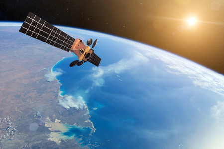 Space satellite orbiting the earth and bright lights Sun.の写真素材