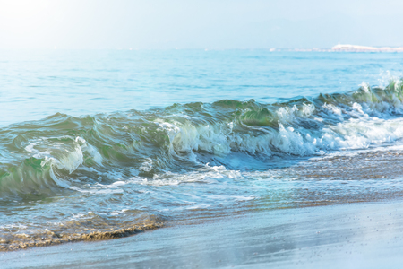 Waves with a green tint on the beachの写真素材
