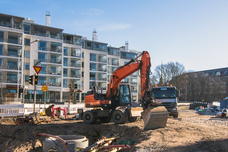 Excavator on a city street, reconstruction of communication along roads and pavements.