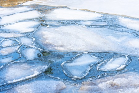 Rounded ice floes in the bay on the water in spring