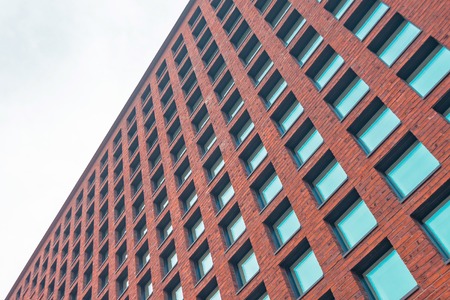High brick wall with square windows and glassの写真素材