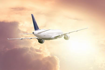 The plane flies on a journey towards the bright light in the sky.の写真素材