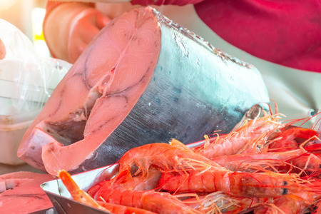 King prawns and a piece of tuna fish swordfish on the market counterの写真素材