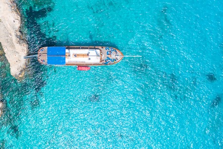 Wooden yacht in the paradise bay at the pier in the ocean, top viewの写真素材