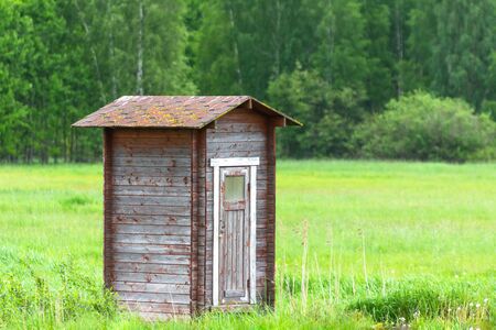 Lonely barn in green field and forestの写真素材