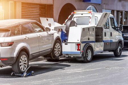 Hooked up car on a tow truck on a roadsideの写真素材