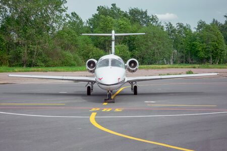 Small jet airplane parked on the airfield at airportの写真素材