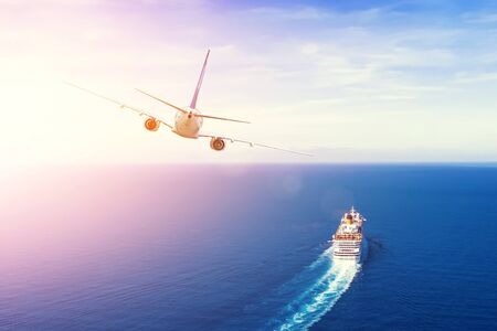 Cruise ship goes into the open sea, plane flies into the sky horizon in the evening at sunset. Travel summer vacation conceptの写真素材