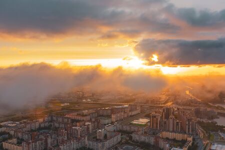 Urban cityscape, aerial top view with low flying clouds over a residential area of the city, view of...