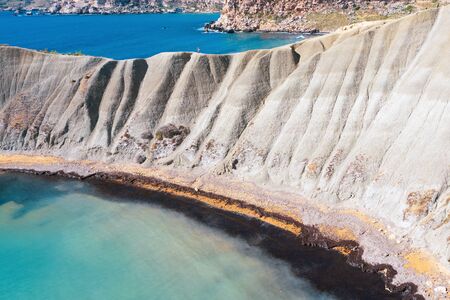 Cliff with steep slopes on the shore in the middle of the Mediterranean, aerial viewの写真素材