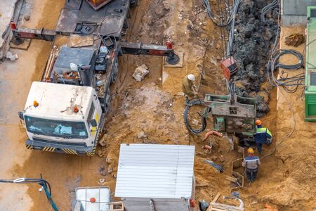 Installation of piles at a building site using an outboard power plant for drilling soilの写真素材