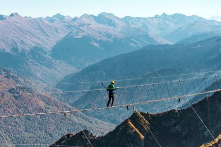 View of the mountain landscape gorge, tourist man walking along an extreme staircase over a precipiceの写真素材