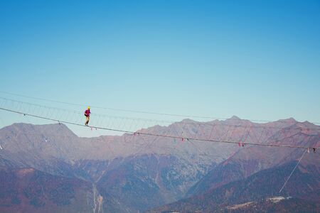 View of the mountain landscape gorge, tourist man walking along an extreme staircase over a...
