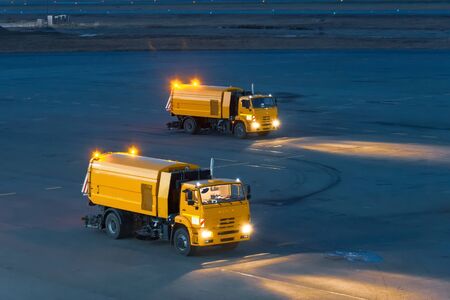 Trucks for cleaning garbage from roads at the airport, at night