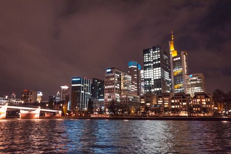 Night view from the embankment of the Main river, on the business center of Frankfurt, Germanyの写真素材