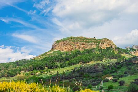 Rock among among meadows and forests against a blue skyの写真素材
