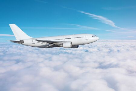 Passenger airplane flying overcast in the daytimeの写真素材