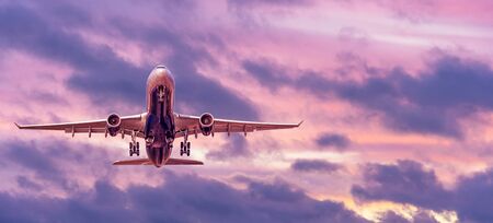 Evening flight, the plane takes off and travels, panoramic view of the sunset skyの写真素材