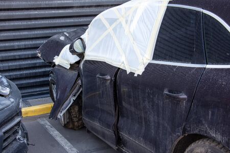 Broken car view of a driver's door with broken glass covered with clothの写真素材