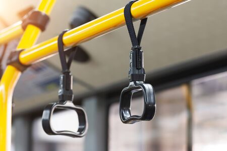 Yellow handrails and black handles to hold passengers steady while the bus is movingの写真素材