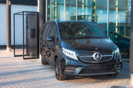 Black luxury van Mercedes-Benz minivan near to the station for charging electric cars. Russia, Saint-Petersburg. 07 april 2020のeditorial素材