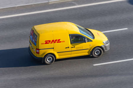 DHL world wide courier company delivery small cargo car on the highway city. Russia, Saint-Petersburg 07 may 2020のeditorial素材