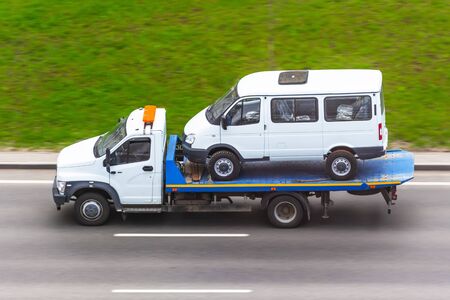 Carriage of a small minibus on the platform tow truckの写真素材