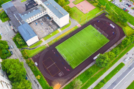 Sports ground with stadium for football, basketball and tennis, jogging tracks around, aerial view