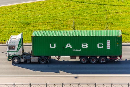 Truck with trailer and green container company UASC on city highway. Russia, Saint-Petersburg. 25...