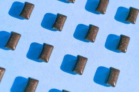 Black chewing gum pads on blue background