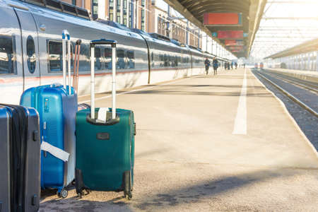 Rolling bags, luggage suitcases on the platform of the railway passenger empty station next to the train, destinationの写真素材