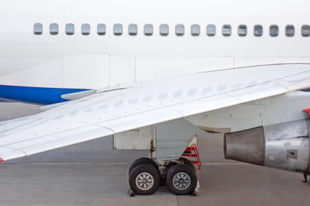 Engine on white fuselage with portholes of passenger plane, jet turbine, windows, wing, aircraft...