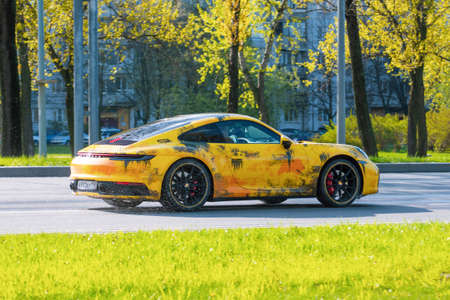 Yellow Porsche 911 Carrera driving along the city street. Russia.Saint-Peterburg, 14 may 2020のeditorial素材