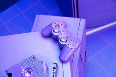 VCR for videotapes, a game joystick lie on a violet, purple vintage TV. Concept for the return of the lifestyle of youth and adolescents in the 80s and 90sの写真素材