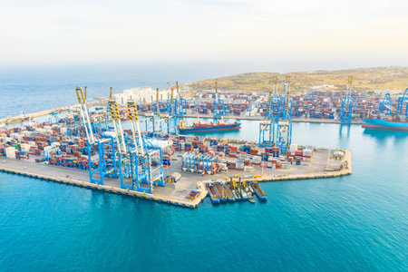 Aerial view from the height of a cargo harbor in a cargo seaport, a sailing ship with containers goods. Malta, Il Brolli Marsaxlokk, Malta-Freeport. 09 may 2019のeditorial素材