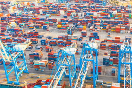 Aerial view from the height of a cargo harbor in a cargo seaport, a sailing ship with containers...