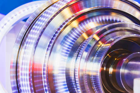 Polished metal part of a disc turbine engine or brake engine, illuminated with iridescent colorsの写真素材