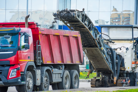 Road cold milling machine removes the old asphalt and loading into a dump truck. Repair of asphalt pavement of the roadの写真素材