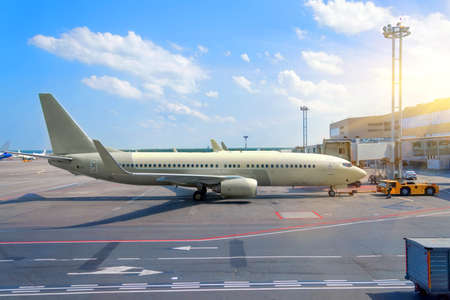 Medium-haul passenger aircraft at the terminal of the airport building in service before the flight