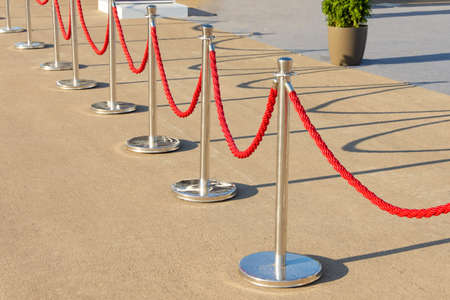 Portable fencing shiny metallic barrier outside. Red carpet safety ropeの写真素材