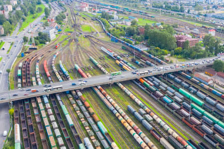 Railway marshalling yard and road bridge above it with cars. Import and export logistics. Industrial...